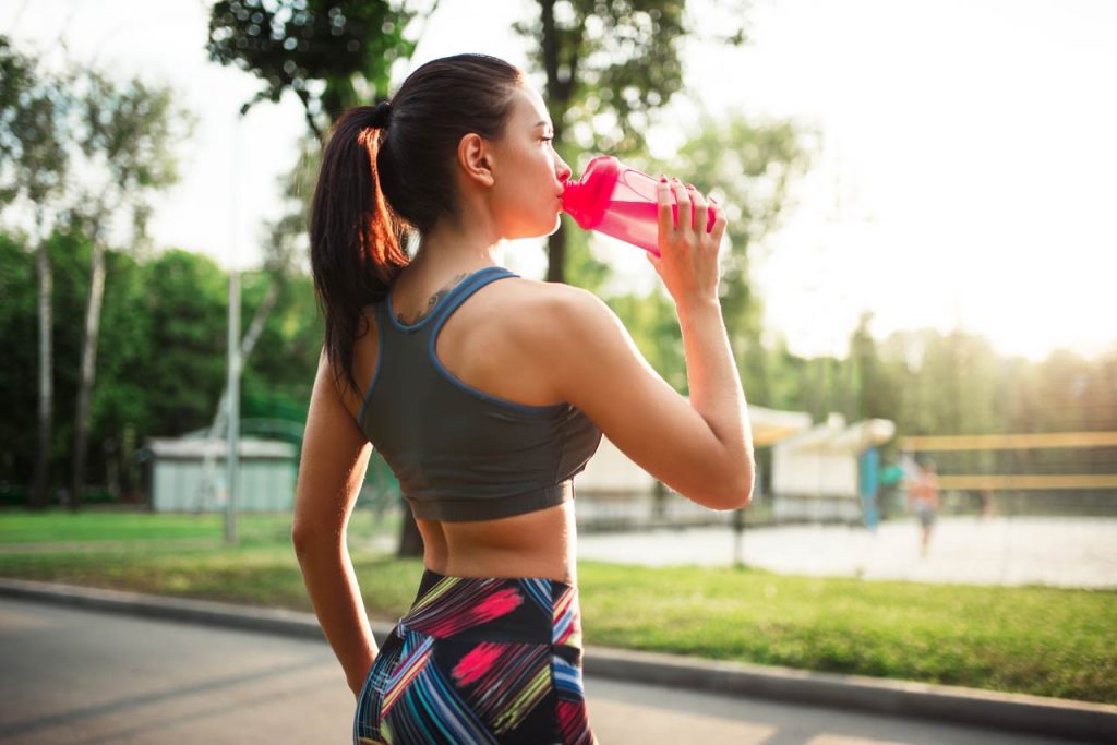 Girl Jogging and drinking health drink from sipper